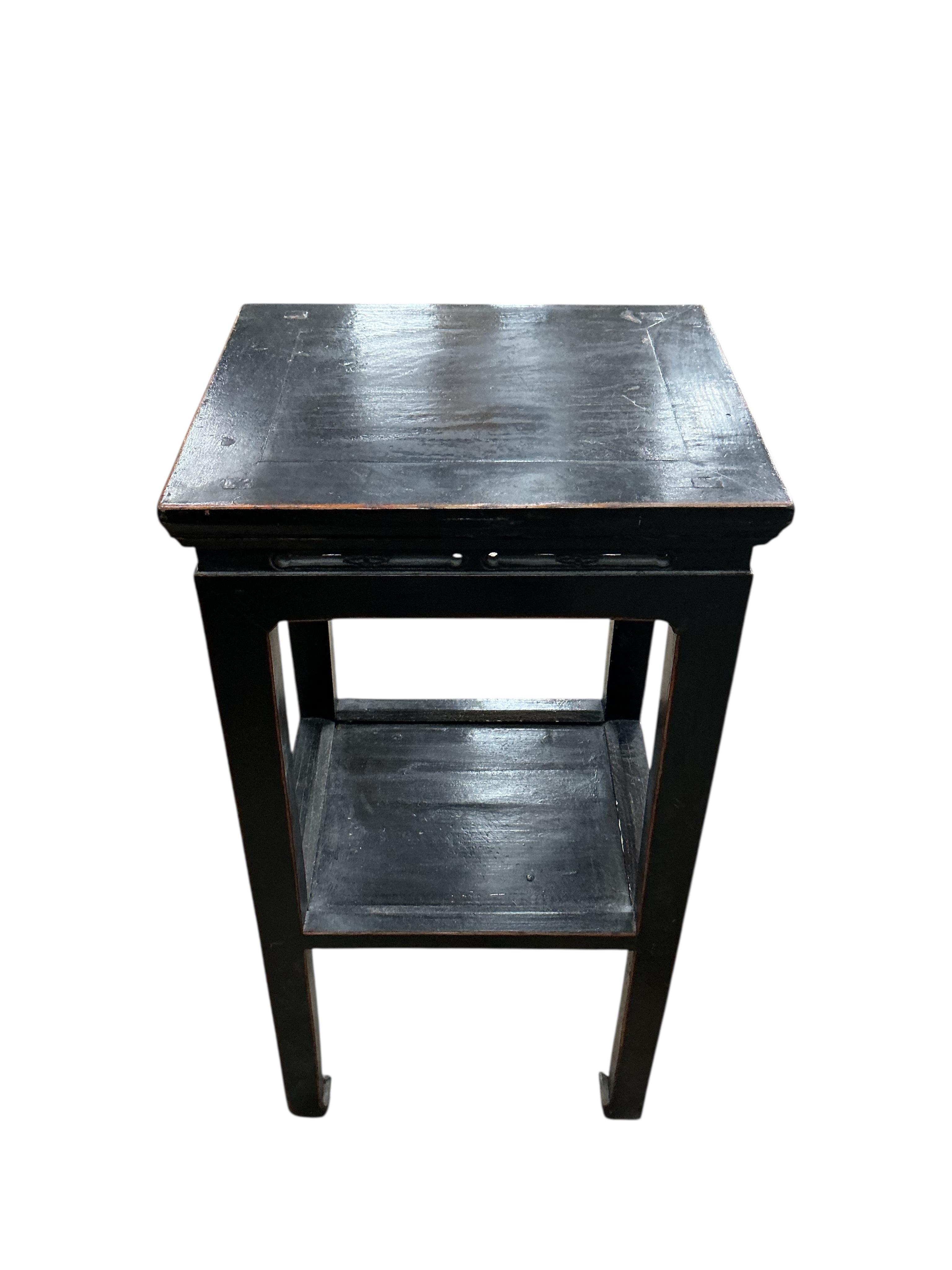 A pair of Chinese lacquer two tier tables, width 41cm, depth 34cm, height 79cm, Provenance: The late Kenneth Turner (1936-2025), celebrity florist, designer and perfume retailer, he received the Royal Warrant from the Pr